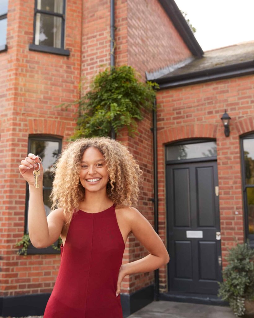 Portrait Of Excited Young Woman Standing Outside New Home Holding Keys Portrait Of Excited Young Woman Standing Outside New Home Holding Keys